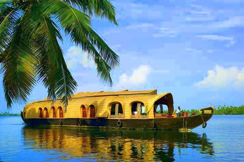 A houseboat in Alleppey traversing the deep blue backwaters